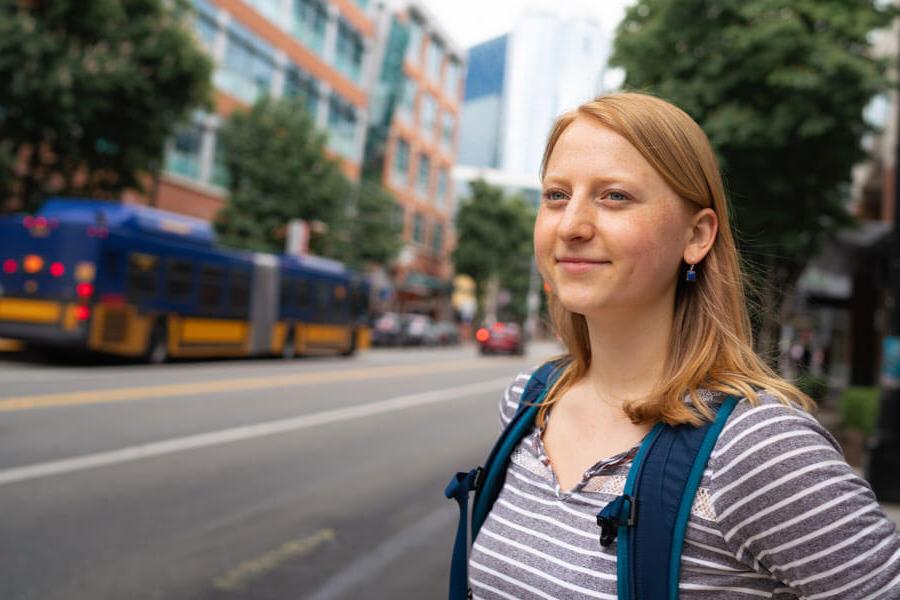 student waits for bus in downtown Seattle